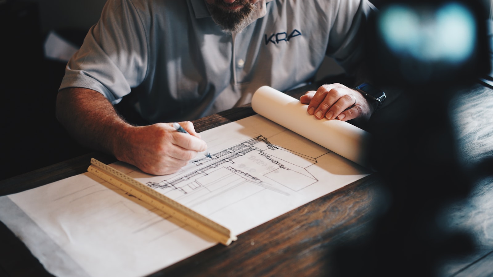 Architect marking up construction drawings on a desk