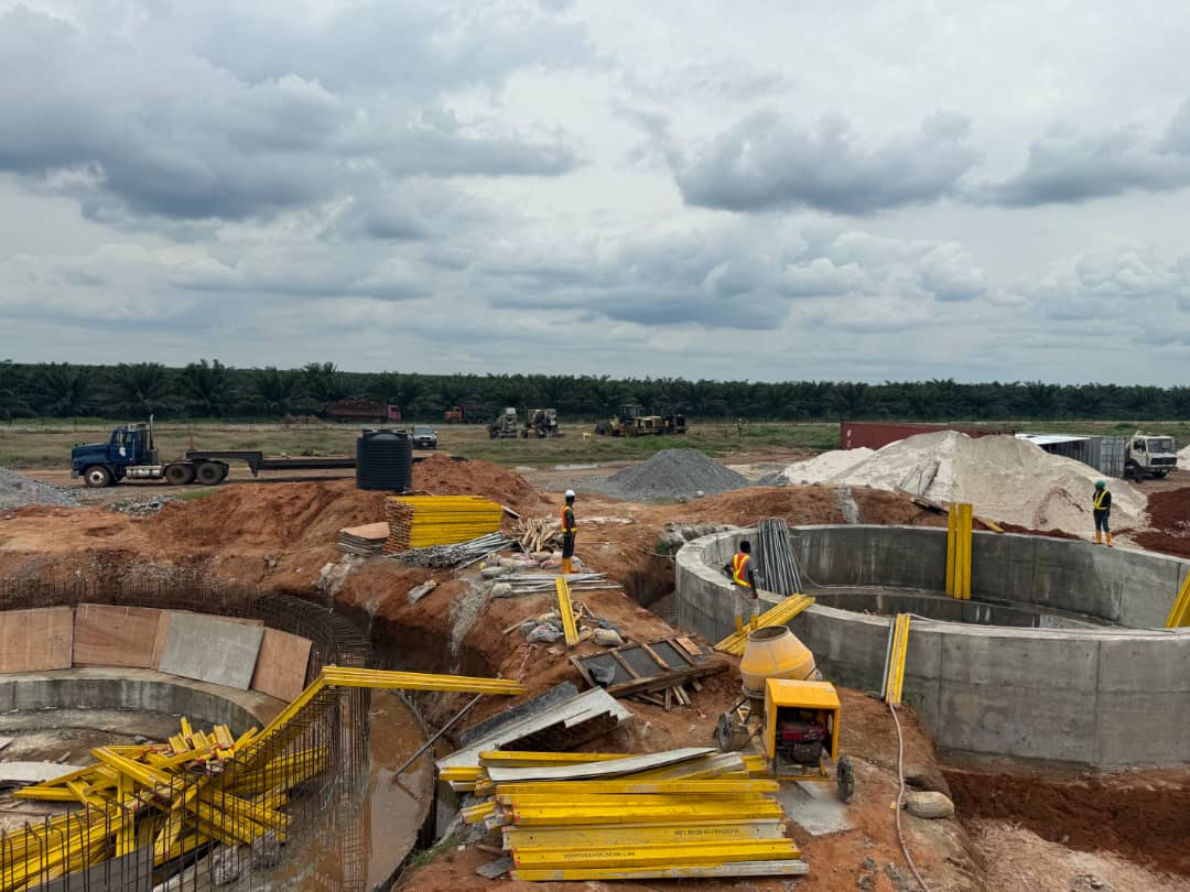Excavation and circular concrete tank foundations with yellow formwork at the Ato Mills site in Edo State