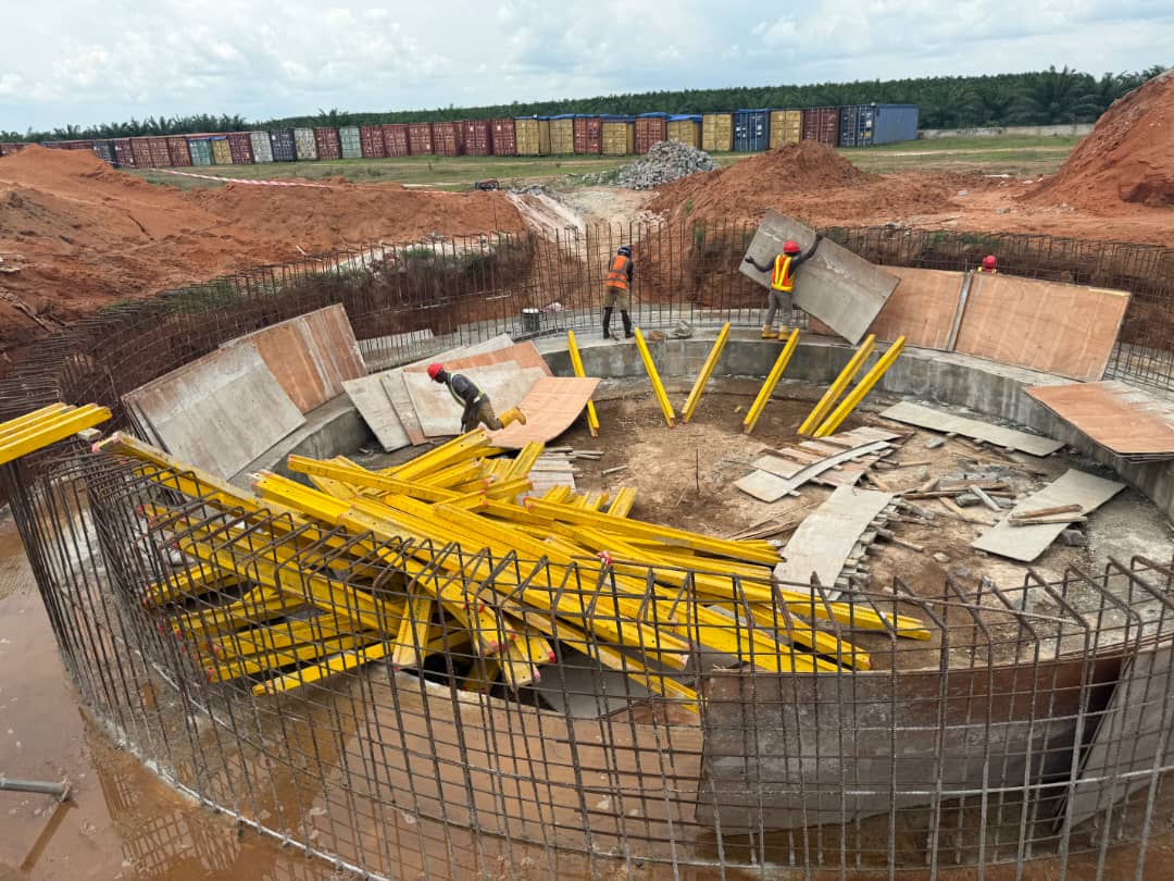 Reinforcement cage and circular formwork for a large concrete tank base with workers on site