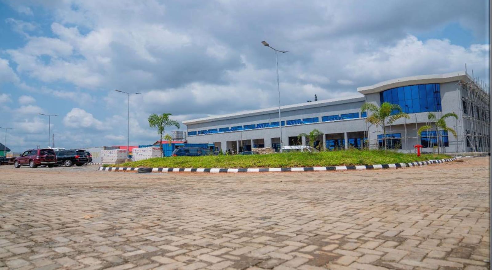 Completed terminal building across the interlock-paved forecourt and landscaped island
