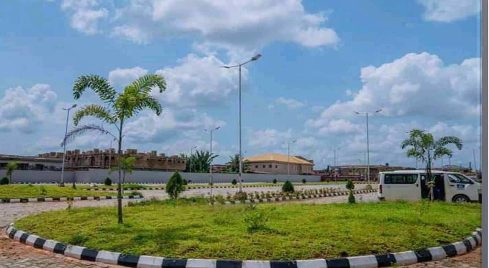 Landscaped island with palm trees and street lights at the Benin Central Bus Terminal