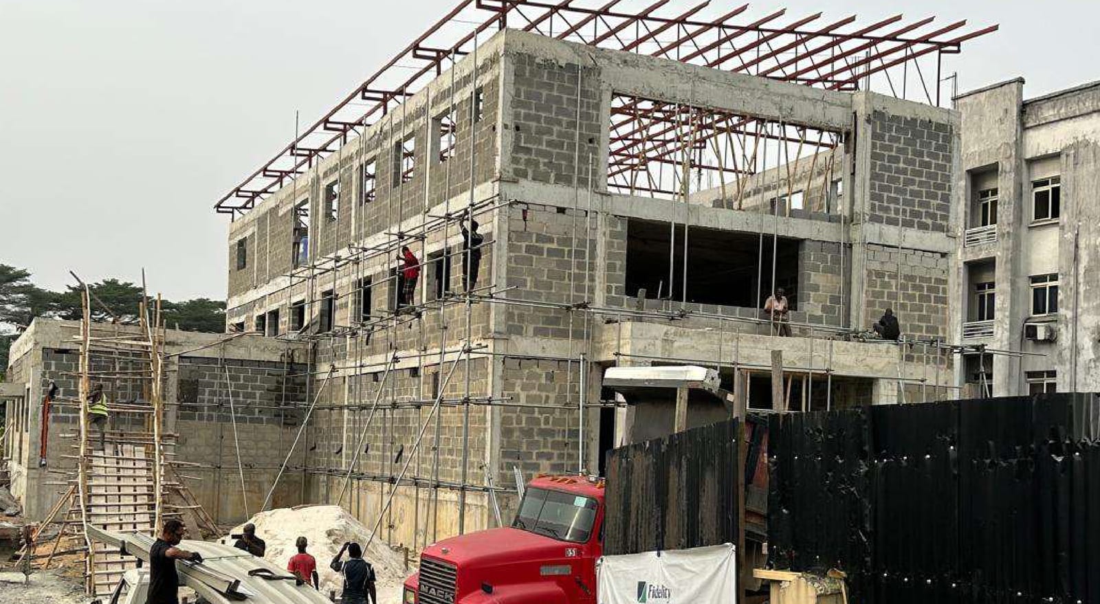 Blockwork rising on the multi-storey frame with workers on scaffolding