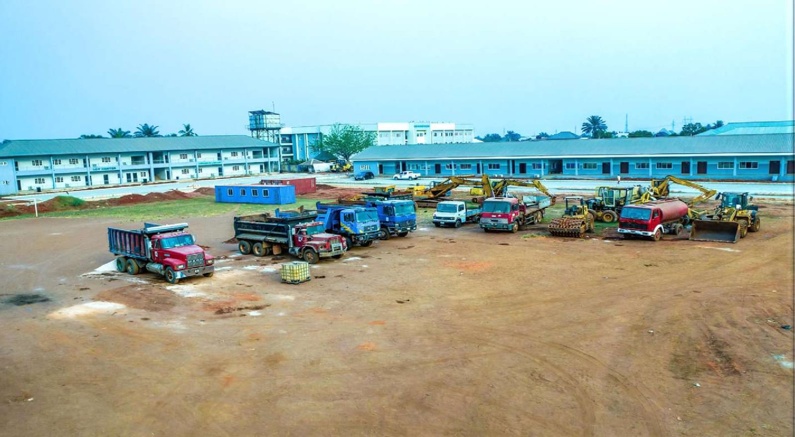 Trucks and earthmoving equipment mobilised on site beside the new academic blocks