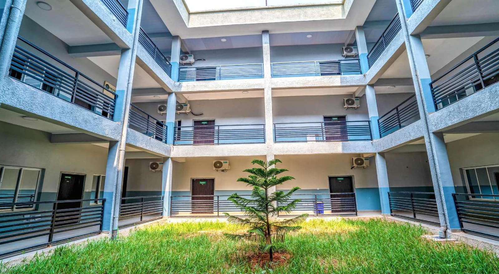 Landscaped inner courtyard of an academic building completed by Pekuric, with walkways and a young tree