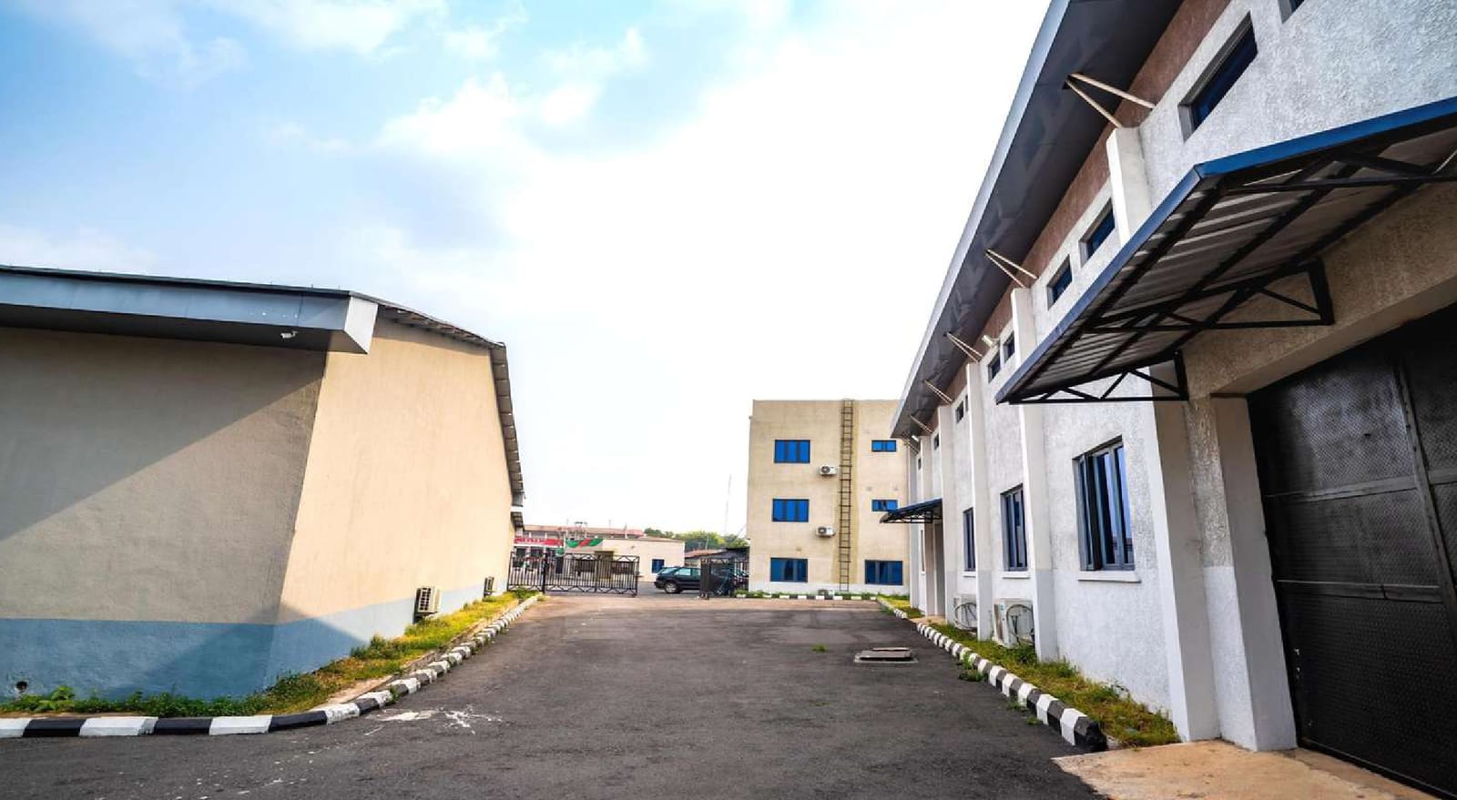 Paved access road running between completed buildings in the Nigerian Observer complex