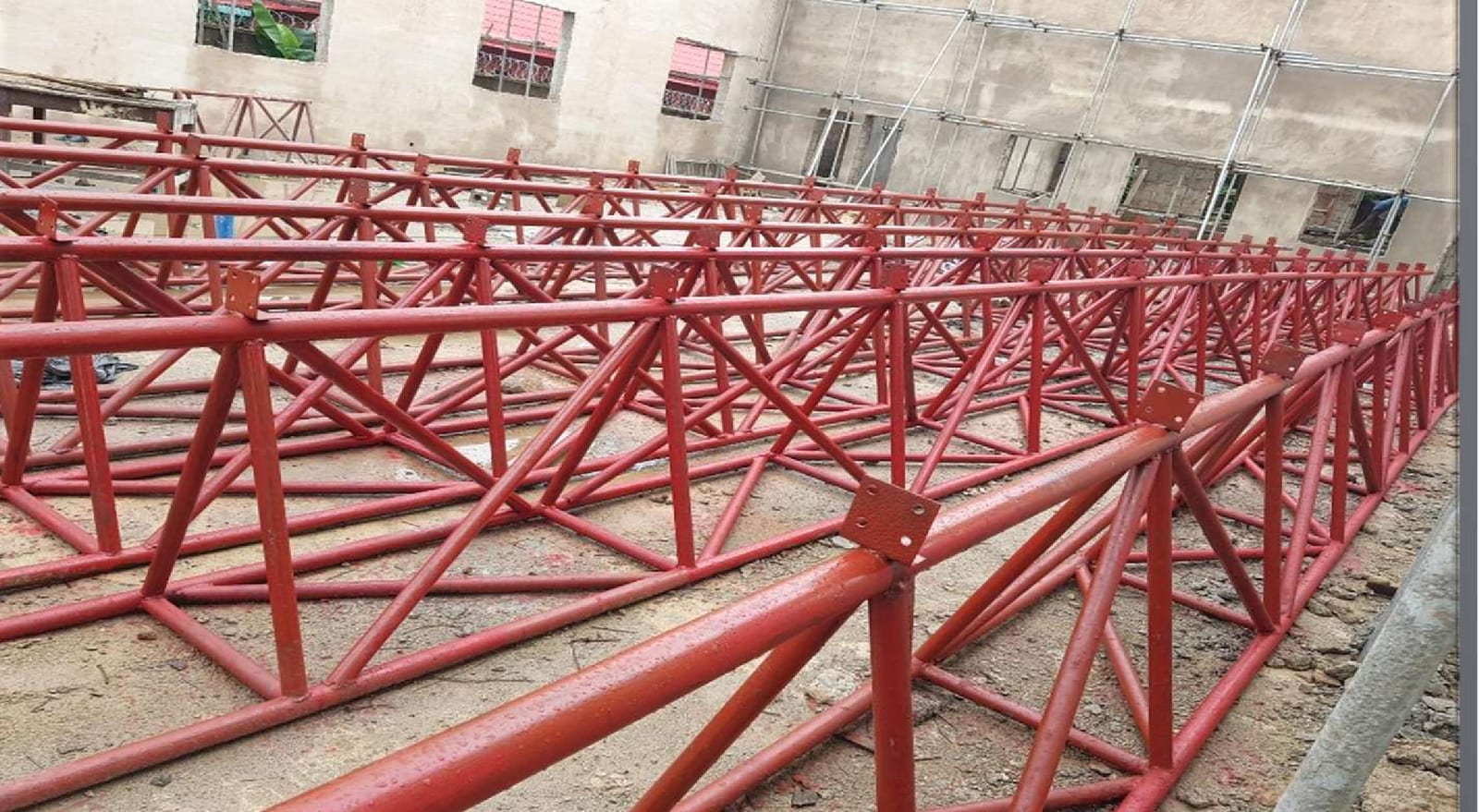 Red steel roof truss work forming part of the Victor Uwaifo Creative Hub